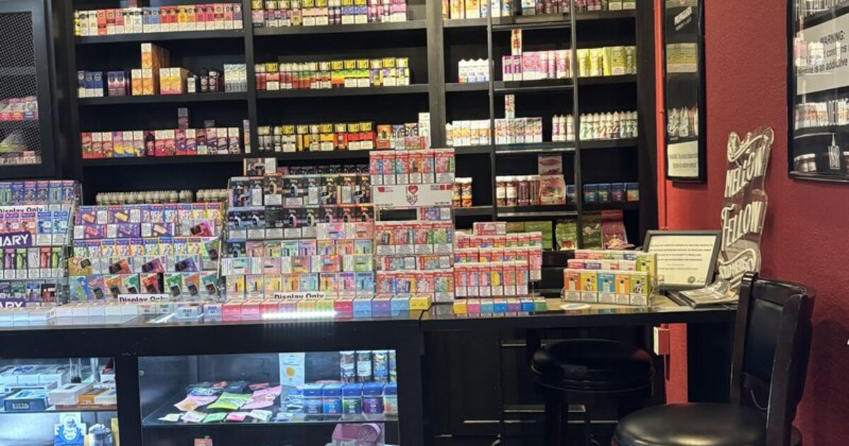 Vape shop counter displaying variety of vaping devices and e-liquids